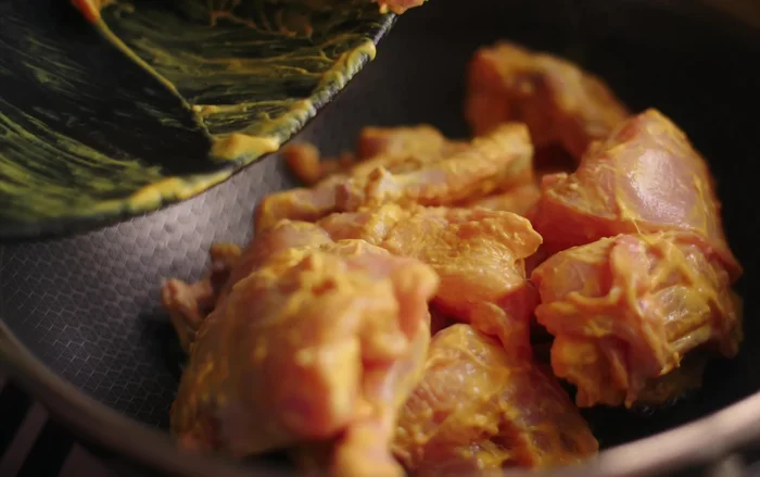Heat ghee in a pan and sear the marinated chicken until it's almost cooked (85-90%).