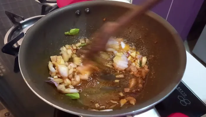 Add ginger-garlic paste and fry until the raw smell is gone. Add chopped tomatoes and fry for a minute or two.