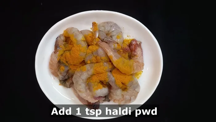 Clean and cut the shrimp. Add turmeric powder and salt, mix well, and set aside for 5 minutes.