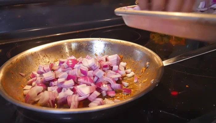 Add oil to the pan, then onions, green chili (if using), and a pinch of salt. Cook until onions are transparent.