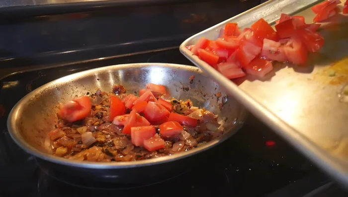 Add tomatoes and ground spices (coriander, turmeric, garam masala, chili powder). Add cashews and cook until tomatoes are soft. Add water if needed.