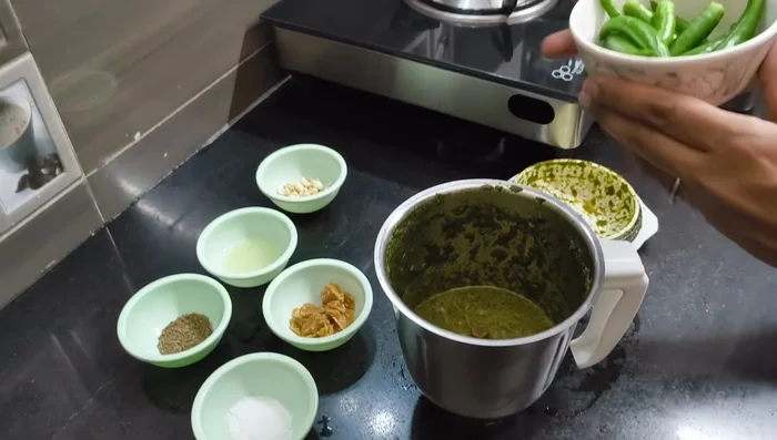 Add green chilies, garlic, jaggery, cumin, lemon juice, and salt to the paste.