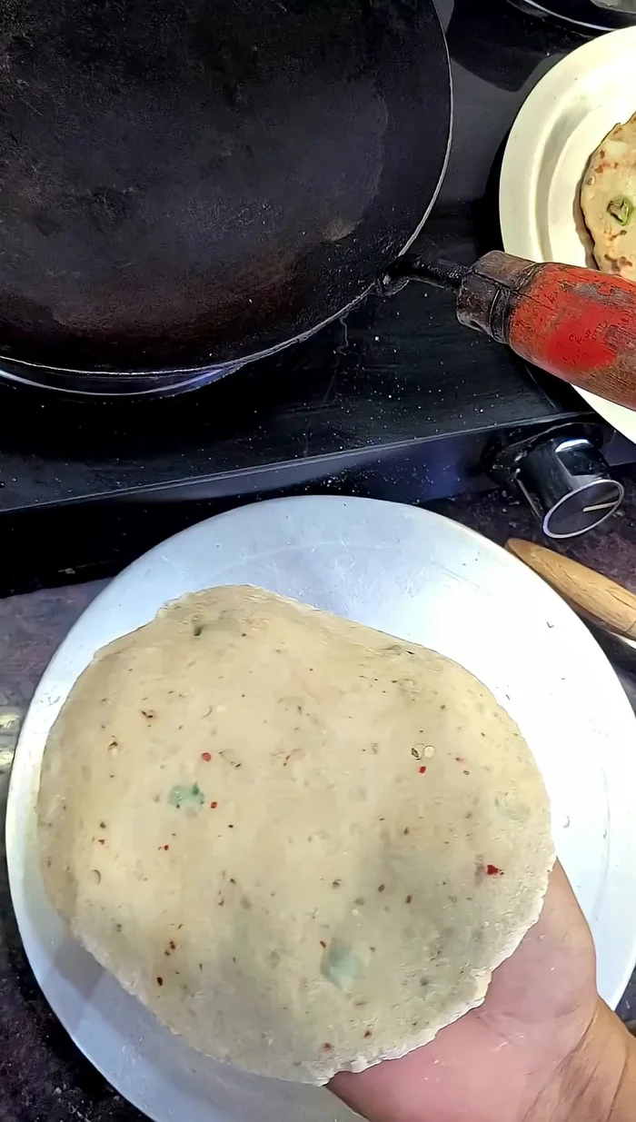 Cook the parathas on a pan over medium heat, applying oil or ghee after partially cooking each side.