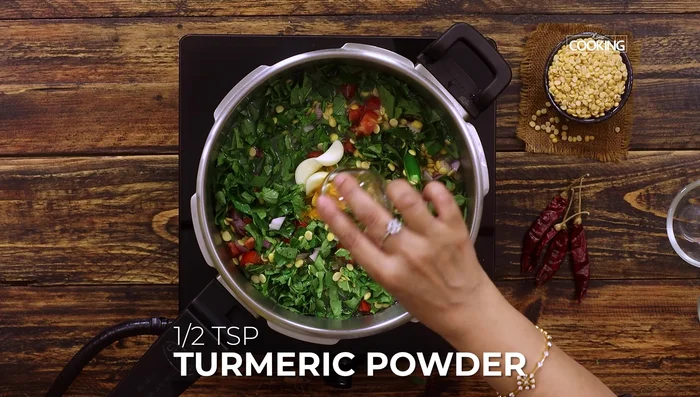 Add the chopped gongura leaves, garlic, and turmeric powder (65.119). Mix well, close the lid, and cook for five whistles on medium flame (70.159).