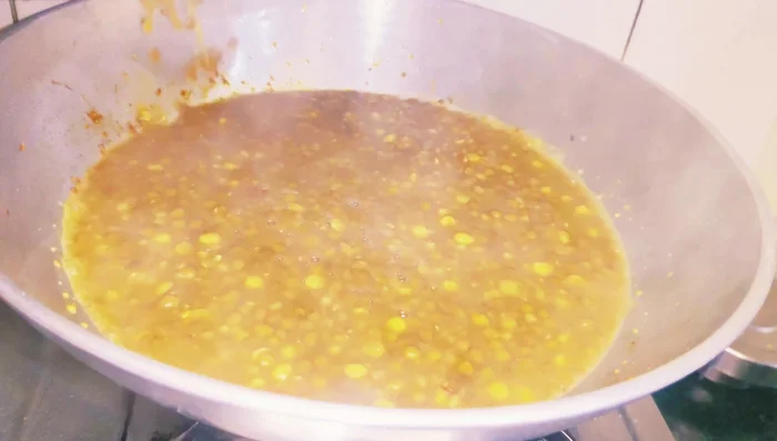 Add the cooked lentils to the spiced mixture and bring it to a boil.