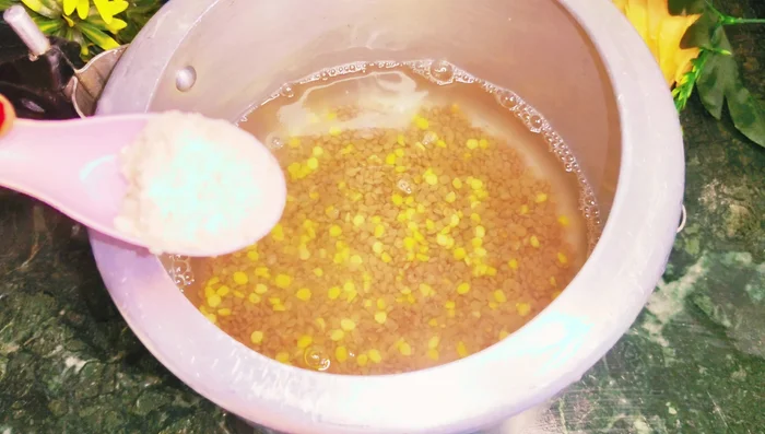 In a cooker, combine 1 cup of black lentils, 4 cups of water, salt, a little asafoetida, and some turmeric powder.