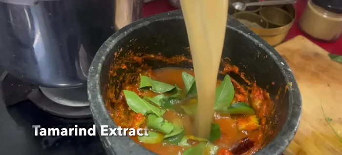 Add curry leaves, tamarind extract, and water. Bring to a boil and simmer until thickened.