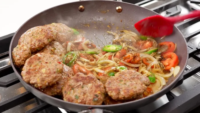 Arrange the cooked kebabs in the pan, top with ginger julienne, and spread curd over the kebabs.