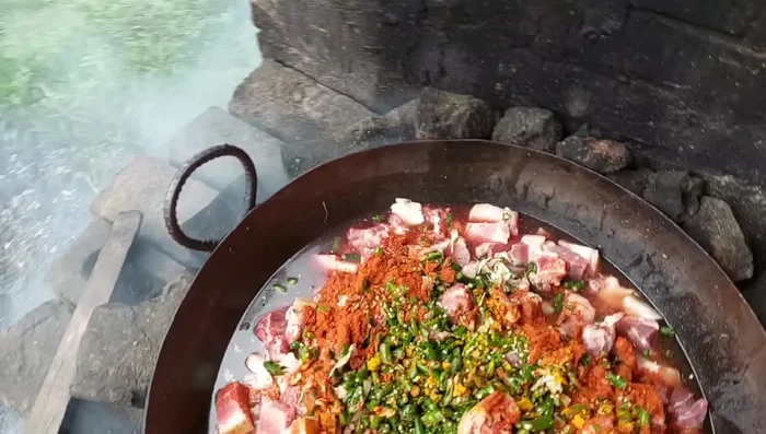 Add chillies and other spices to the marinated pork.