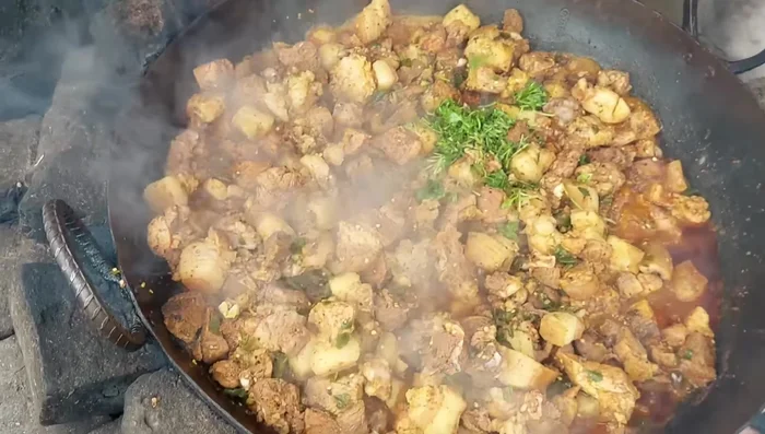 Once the pork is almost cooked, sprinkle green coriander leaves on top.
